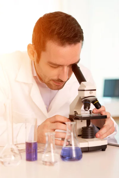 Jeune homme attrayant travaillant dans un laboratoire Photos De Stock Libres De Droits