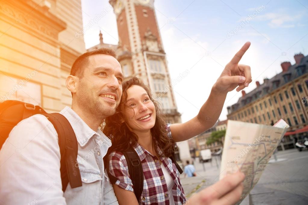 Couple of young attractive tourists watching map 