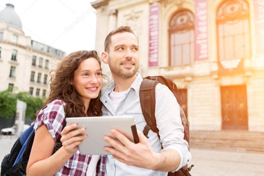 Couple of young attractive tourists watching map 