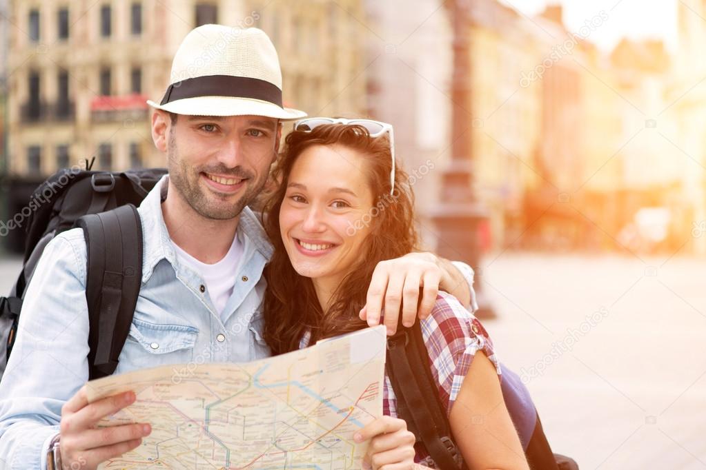 Couple of young attractive tourists watching map 