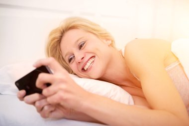 Genç çekici kadın yatakta ttext gönderme