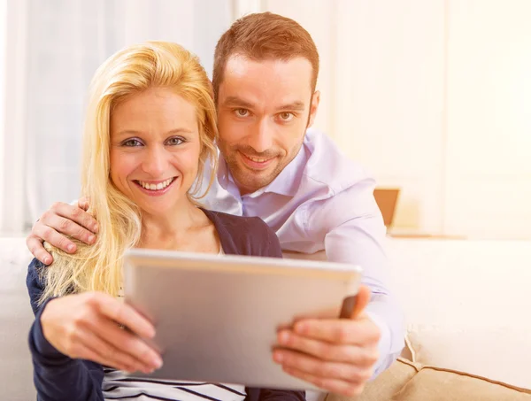 Jovem casal atraente se divertindo usando tablet — Fotografia de Stock