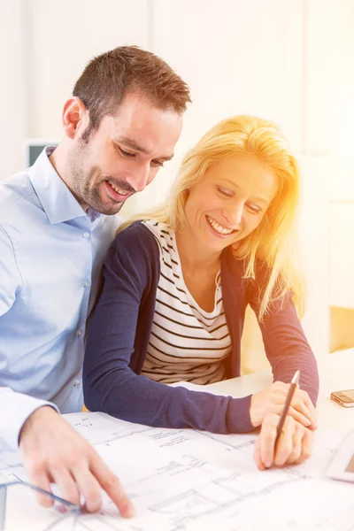 Young couple studying plans of their future house — Stock Photo, Image