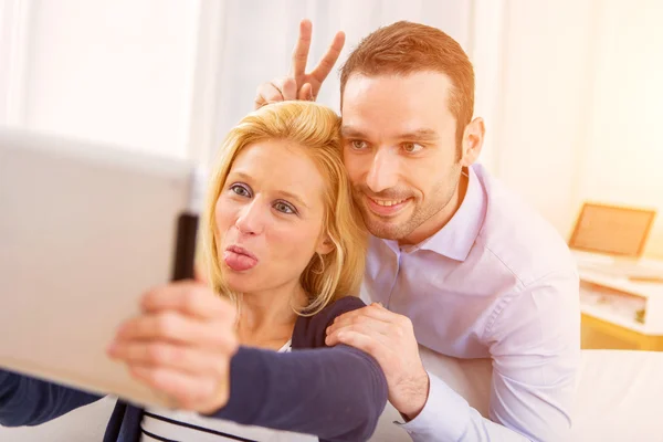Joven pareja atractiva divirtiéndose usando tableta — Foto de Stock