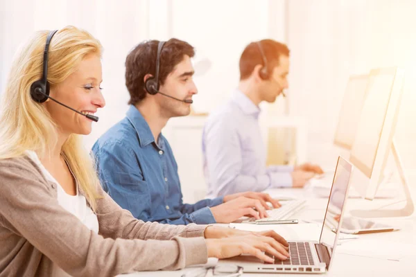 Ung attraktiv kvinna som arbetar i ett callcenter — Stockfoto