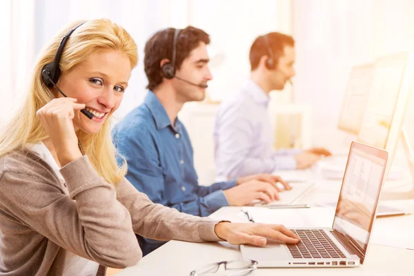 Ung attraktiv kvinna som arbetar i ett callcenter — Stockfoto