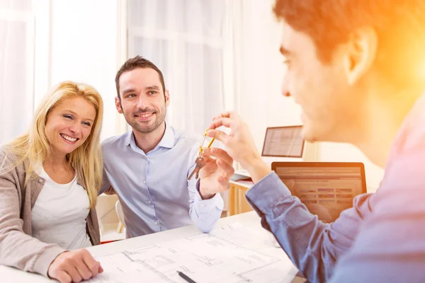 Young serious couple meeting a real estate agent — Stock Photo, Image