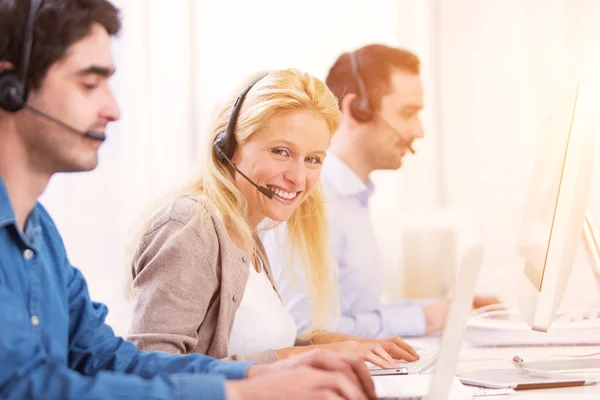 Ung attraktiv kvinna som arbetar i ett callcenter — Stockfoto