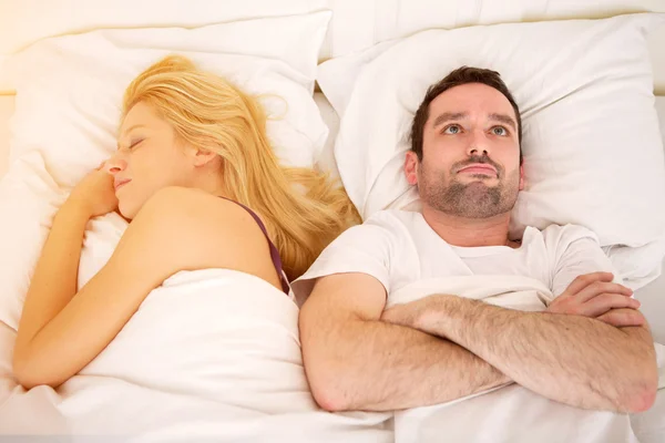 Junge attraktive nachdenkliche Mann in einem Bett — Stockfoto