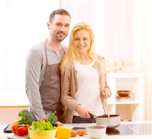 Jovem casal atraente cozinhar em uma cozinha — Fotografia de Stock