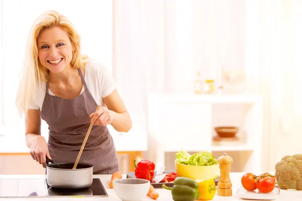 Junge attraktive Frau kocht in einer Küche — Stockfoto