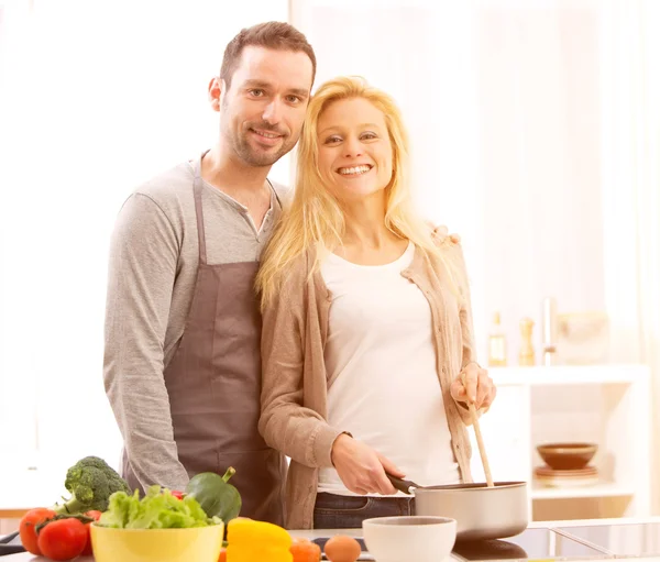 Jovem casal atraente cozinhar em uma cozinha — Fotografia de Stock