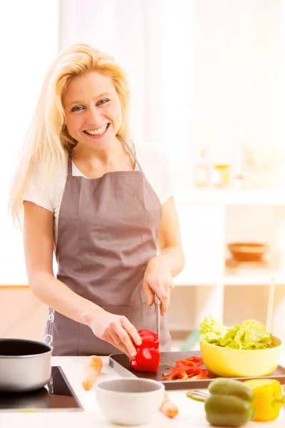 Young attractive woman cooking in a kitchen — Stock Photo, Image