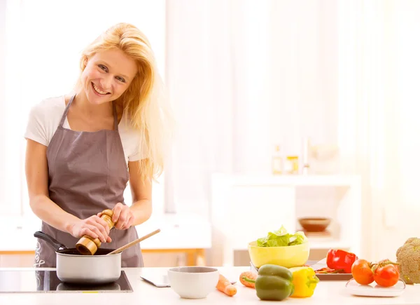 Jovem mulher atraente cozinhar em uma cozinha — Fotografia de Stock