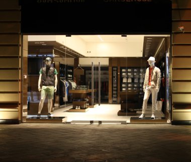 night shopwindow with men dressed mannequins clipart