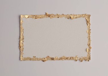Bej rengi gri kağıdın arka planında altın (bronz) parıltılı boş tuval çerçeve. Soyut kopyalama alanı dokusu.