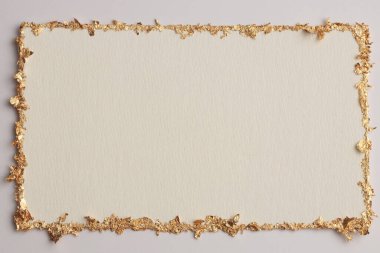 Bej rengi gri kağıdın arka planında altın (bronz) parıltılı boş tuval çerçeve. Soyut kopyalama alanı dokusu.