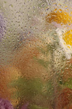 Yumuşak odak çiçeği buketi, su damlalarıyla dolu cam yapraklar. Soyut doğal sarı, bej arkaplan.