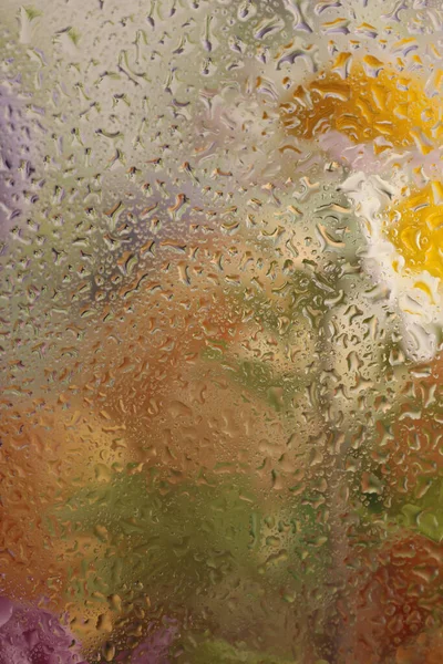 Yumuşak odak çiçeği buketi, su damlalarıyla dolu cam yapraklar. Soyut doğal sarı, bej arkaplan.