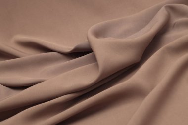 Mocha bej, kahverengi kumaşlı dalga podyum ipek kumaş. Soyut ışık ve gölge dokusu sanat arkaplanı.