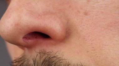 Adam sol burun deliğini karıştırıyor, kaşınan burnunu kaşıyor, koku alamıyor, yakından bakıyor.