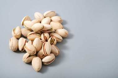 Bir yığın taze fıstık, organik yağ vejetaryen ya da vejetaryen için atıştırmalık, fotokopi alanı olan gri arka plan.