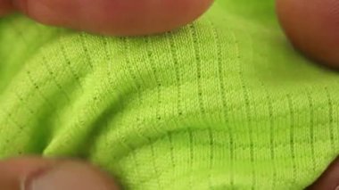 Eller denemesi ve esnetilebilir yeşil spor solunabilir sentetik kumaş, koşu ve zindelik için buhar geçirgen tekstil, yakın çekim makro görünüm