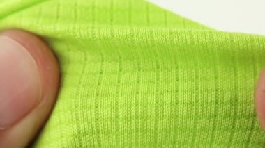 yeşil spor solunabilir sentetik kumaş, koşu ve zindelik için buhar geçirgen tekstil, el esneme testi, yakın çekim makro görünüm