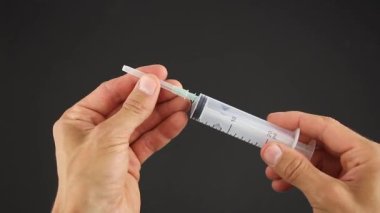 Siyah arkaplan testi, tek kullanımlık şırınga, iğnenin kapağını çıkar.