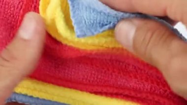 Renkli mikrofiber tozları ayıran eller su emen sentetik kumaşlar, yakın çekim görüntüler, ev temizlik ekipmanları.