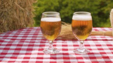 İki bardak bira, olgun buğday kulakları, taze saman ve arpa ya da açık havada çuval içinde buğday taneleri. Kamera yavaşça kaydırakta hareket ediyor.