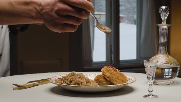 Twee gebakken koteletten en bulgur op een bord — Stockvideo
