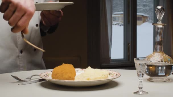 Manos de un chef poniendo chuleta frita en el plato — Vídeos de Stock