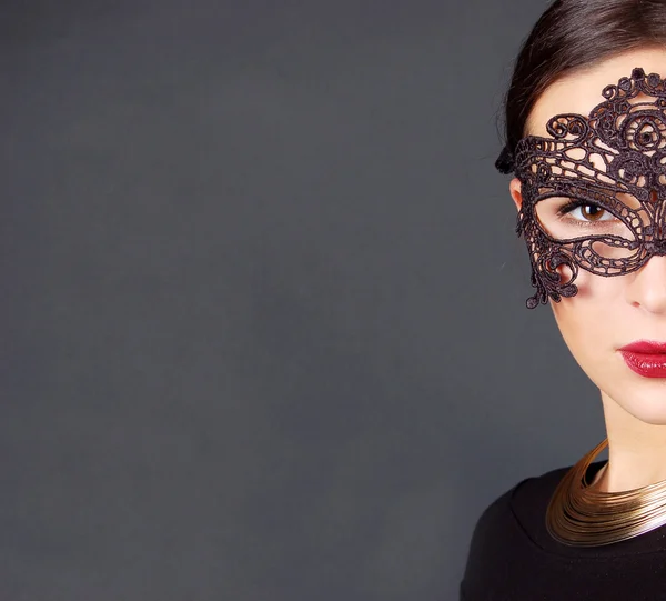 Schöne junge Frau in schwarzer mysteriöser Maske isoliert — Stockfoto