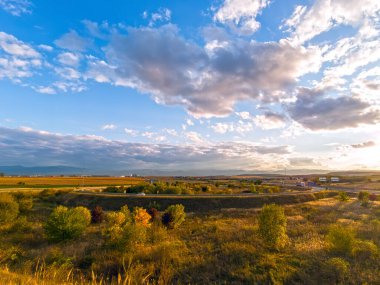 Romanya 'nın Transilvanya kentindeki manzara, Sibiu yakınlarında, tarlalar, karayolu altyapısı ve arka planda dağ sıraları, yaz sonu