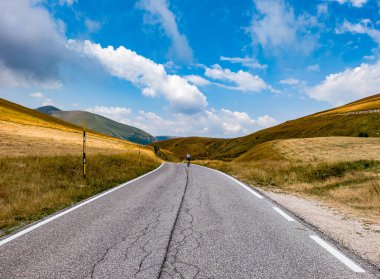 Sassotetto Geçidi 'ndeki dağ yolunda bisikletçi, Marche, İtalya manzaralı zirveler ve dayanıklılık ruhuyla, spor, seyahat ve açık hava fotoğrafçılığı için mükemmel..