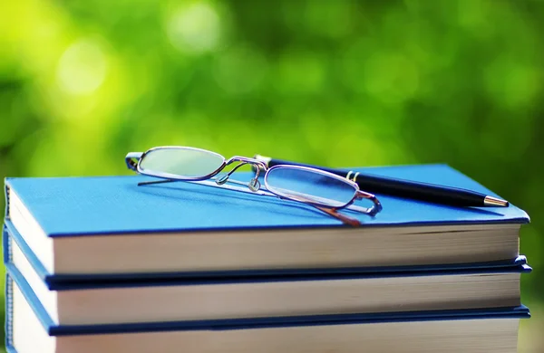 Books and glasses on green background — Stock Photo, Image
