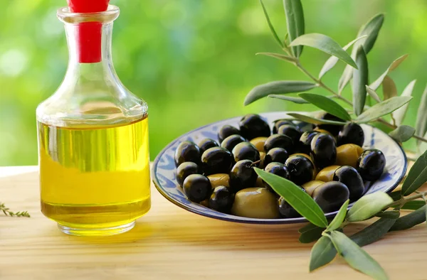 Olives on plate and oliveoil — Stock Photo, Image