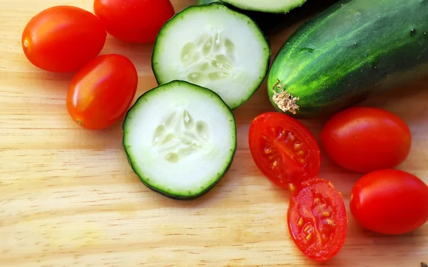 Komkommer en tomaten op tafel — Stockfoto