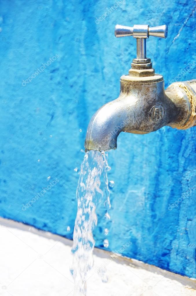 Old water faucet against blue wall Stock Photo by ©inaquim 114037806