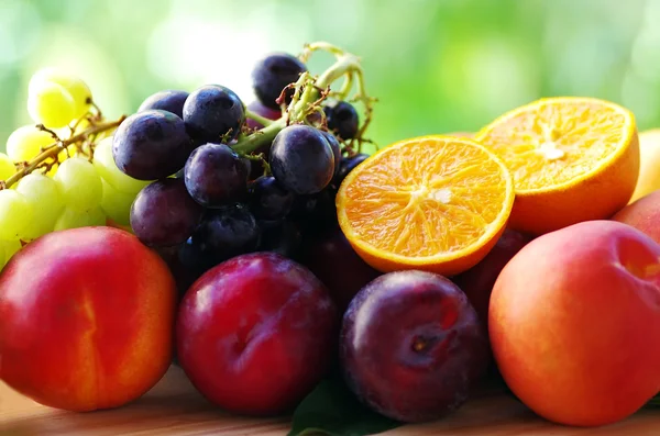 Laranjas, uvas, pêssegos e ameixas em fatias maduras — Fotografia de Stock