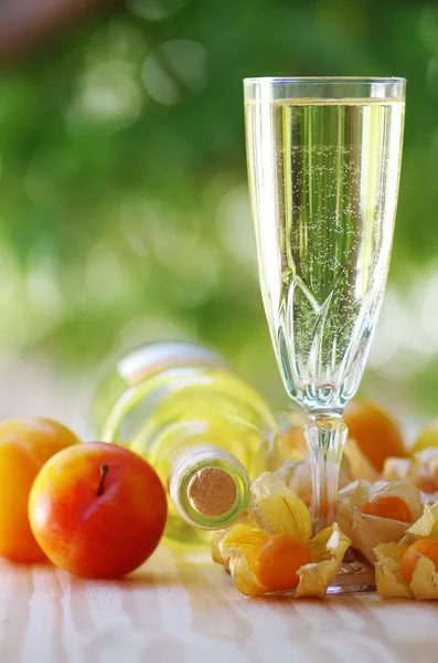 Garrafa de vinho branco, vidro e frutas — Fotografia de Stock