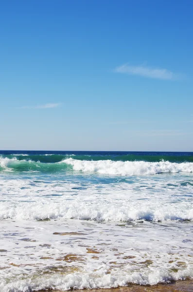 Yeşil su ve mavi gökyüzü ile plaj manzara — Stok fotoğraf