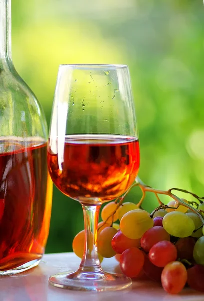 Glass of rose wine and grapes — Stock Photo, Image