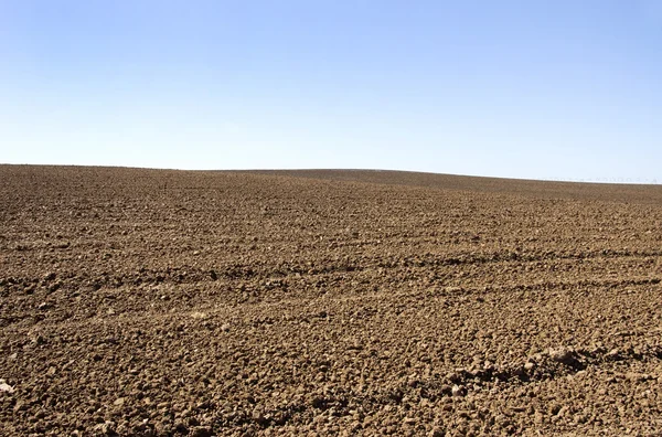 Arado agrícola solo e céu azul — Fotografia de Stock