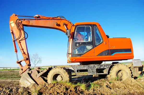 Orangefarbener Bagger auf Arbeitsbühne — Stockfoto