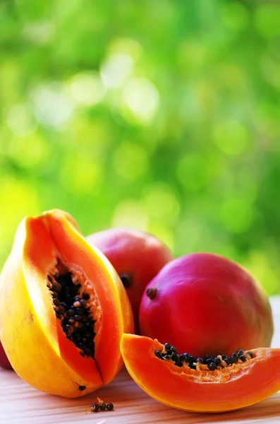 Нарезанные фрукты папайи и манго на столе . — стоковое фото