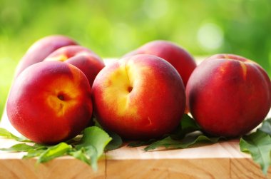 Şeftali ve yapraklar masada