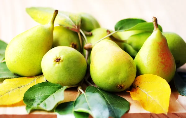 Pears with leaves on the wooden table — Stock Photo, Image