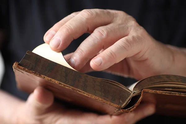 Older man looks at vintage book  — 图库照片